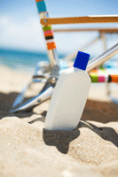 sunscreen bottle in sand